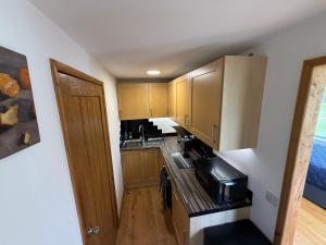 a kitchen with wooden cabinets and a stove top oven at Summerhouse in Honington