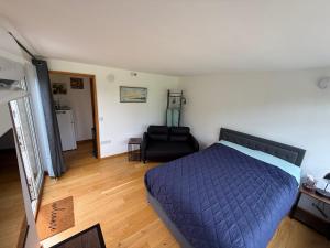 a bedroom with a blue bed and a black chair at Summerhouse in Honington