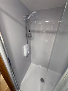 a shower with a glass door in a bathroom at Summerhouse in Honington +10 photos