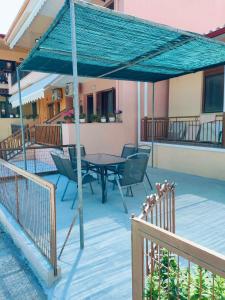 a patio with a table and chairs under a blue canopy at Barefoot Nest in Nea Skioni