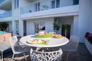 Ein weißer Tisch mit Tellern voller Essen auf einer Terrasse in der Unterkunft Le Stanze e il Mare in Polignano a Mare