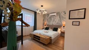 a bedroom with a bed and a vase with flowers at Malu Apartman in Sárvár