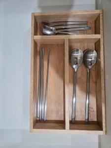 a wooden holder with silver utensils in it at 여유스테이 2호점 in Suwon
