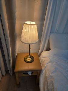 a lamp on a table next to a bed at 여유스테이 2호점 in Suwon