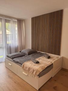 a bed in a bedroom with a large window at Adriany apartmán in Bayerisch Eisenstein