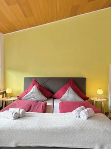 a bedroom with a large bed with red and white pillows at Gartenstudio Anila in Cochem