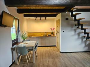 a kitchen and dining room with a table and stairs at Wśród Drzew - Tykocin in Tykocin +14 photos