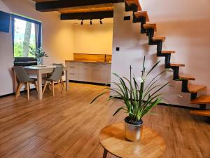 a living room with a table and a staircase at Wśród Drzew - Tykocin in Tykocin