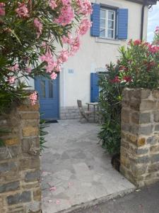 a house with a blue door and pink flowers at Pr' Tekcu in Dekani