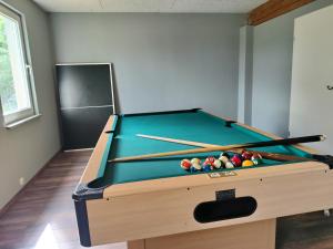 a room with a pool table with cue sticks at Landperle klein und fein in Altenhof
