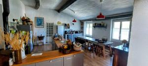 a large kitchen with a table and a counter top at La Fischaumière in Soleilhas