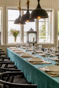 a long blue table with chairs and glasses and lights at Historic lakeside villa - sauna, ski, boat, 20 guests in Sunnansjö +66 photos