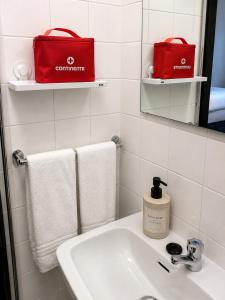 a bathroom with a sink and a red bag on a mirror at Espaço-Zero Downtown Porto in Porto