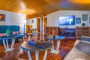 a living room with two tables and a tv at Holiday In Homestay in Shimla