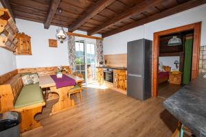 a kitchen with wooden floors and a table with chairs at Hansbauer Appartments in Gmünd in Kärnten