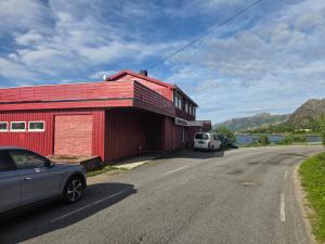 a red building with a car parked next to a road at Grønningbrygga in Grønning