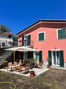 a house with a patio with chairs and an umbrella at Cà da Trûcca in Varazze
