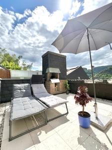a chair and an umbrella on a patio at Gartenstudio Anila in Cochem