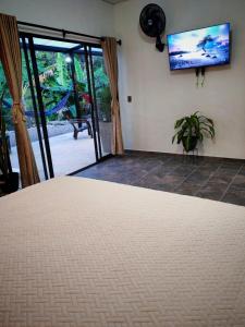 a bedroom with a bed and a tv on the wall at Villa Milú Refugio boutique in Guaduas