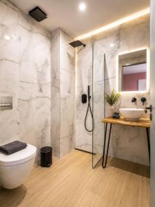 a bathroom with a shower and a toilet and a sink at ATHONITE all seasons luxury suites in Ierissos +24 photos