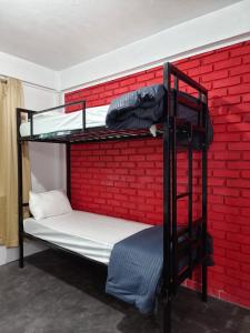 two bunk beds in a room with a brick wall at Heijo's Travellers Nest in Jarain