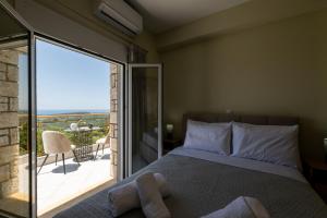 a bedroom with a bed and a balcony with a view at Anima Horizon - Thea apartment in Elaiófiton