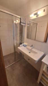 a bathroom with a sink and a shower at Haus Alpenfriede in Weissensee +50 photos