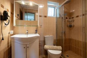 a bathroom with a sink and a toilet and a shower at Anima Horizon - Thea apartment in Elaiófiton +30 photos