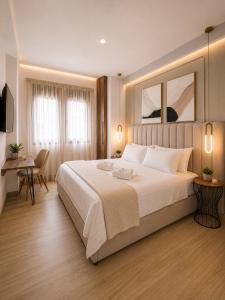a bedroom with a large white bed and a desk at ATHONITE all seasons luxury suites in Ierissos