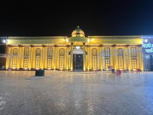a large yellow building with lights on it at night at Laxmi Kantam Vatika in Patna