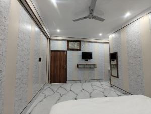 a room with a bed and a tv on the wall at Laxmi Kantam Vatika in Patna