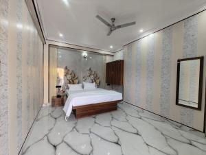 a bedroom with a large white bed and a wall with patterns at Laxmi Kantam Vatika in Patna