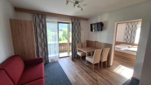 a living room with a red couch and a table at Haus Alpenfriede in Weissensee
