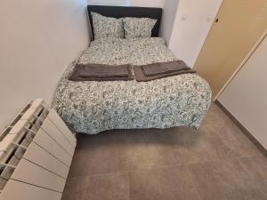 a small bedroom with a bed with at La Campanule in Saint-Cyr-en-Pail