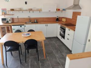 a kitchen with a table and chairs and a refrigerator at Chez Audrey in Courthézon