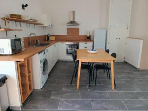 a kitchen with a wooden table and a table and chairs at Chez Audrey in Courthézon