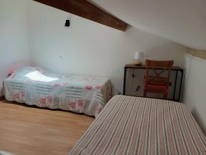 a bedroom with two beds and a chair and a table at Chez Audrey in Courthézon