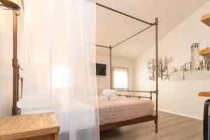 a bedroom with a canopy bed with a window at Chioggia Rooms in Chioggia