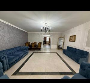 a living room with blue couches and a dining room at Tevosyan Gold EVN Airport in Pʼarakʼar