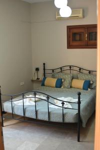 a bedroom with a bed with blue and yellow pillows at Το περασμα in Panormos Kalymnos