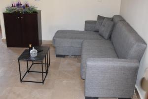 a living room with a gray couch and a table at Το περασμα in Panormos Kalymnos
