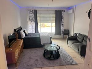 ein Wohnzimmer mit einem Bett, einem Tisch und einem Sofa in der Unterkunft Waterfront in Saint Martin