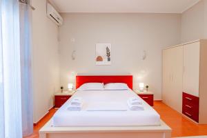 a bedroom with a large white bed with a red headboard at Blue Stay Boutique Hotel in Himare +37 photos