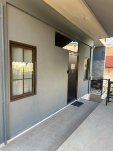 a building with a door and a window and a porch at Letsios Steel1 in Kalabaka