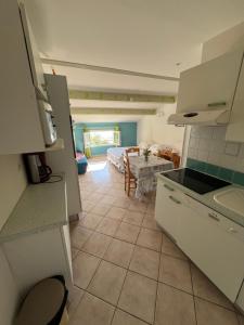 a kitchen and a living room with a table and a couch at vue mer Studio 2/3 pers 1 bed + 1 cot in Farinole