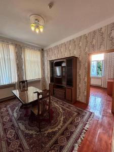 a living room with a wooden table and a dining room at STOP otel in Sheki