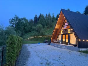 a house with lights on the side of it at Riverside A-frame in Borşa