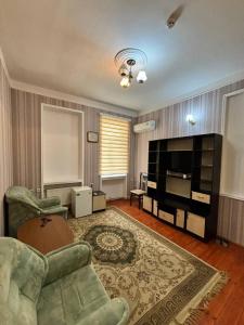 a living room with a couch and a television at STOP otel in Sheki
