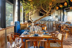 ein Restaurant mit Holztischen und -stühlen und Weingläsern in der Unterkunft Casa de Adobe Gallery & Luxury Boutique in Oaxaca de Juárez