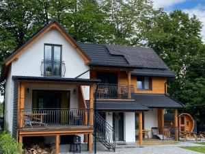 a house with solar panels on the roof at Apartamenty JENDRYCÓWKA in Korbielów